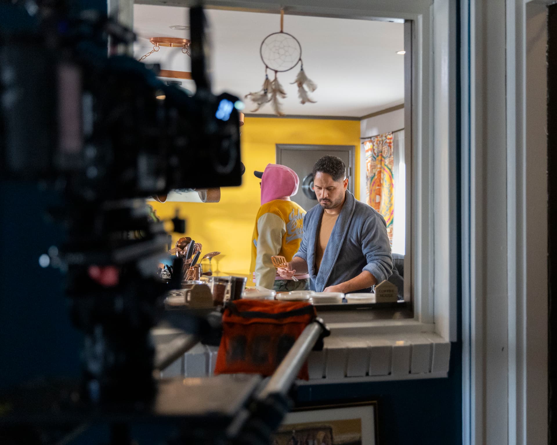 Actor performing a kitchen scene framed through a window